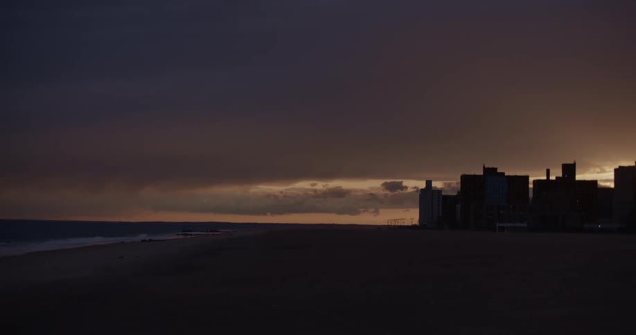 A city skyline at sunset near a beach