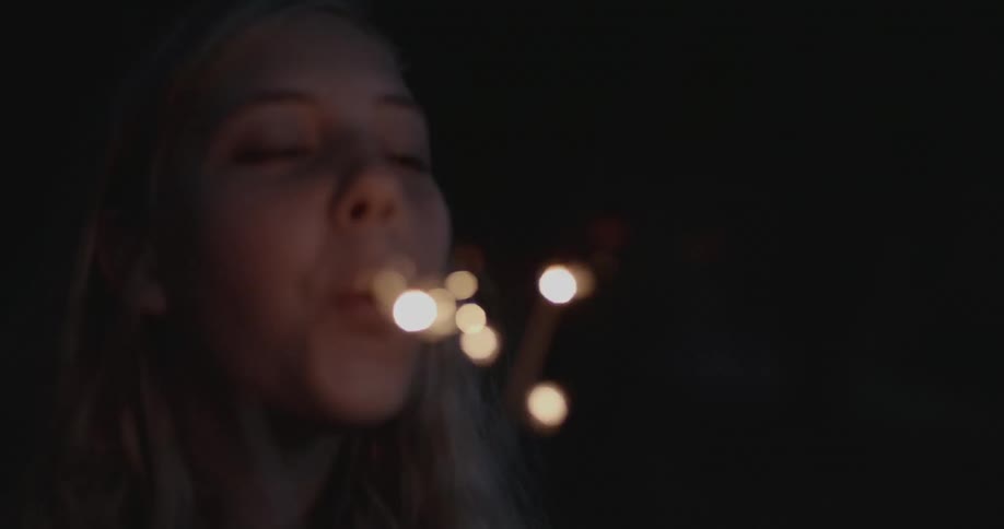 A girl is blowing on a sparkler