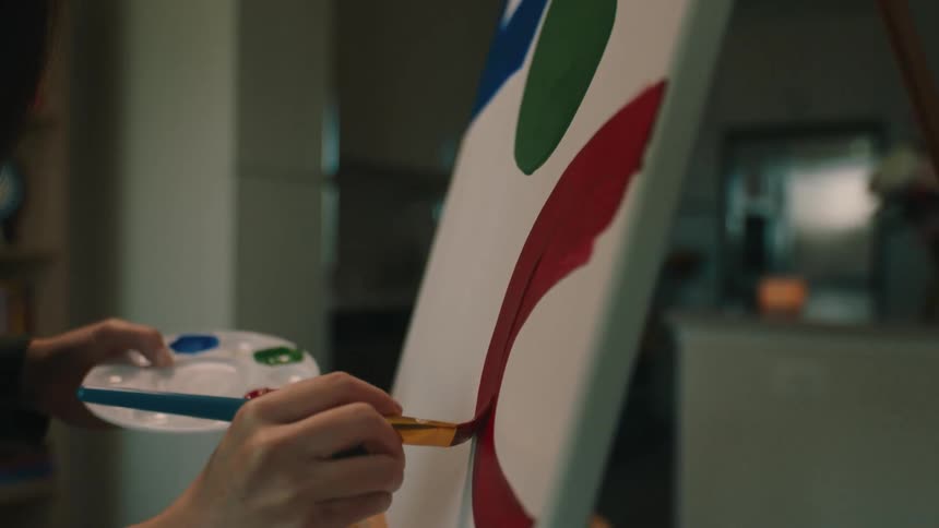 Woman passing the brush on a painting