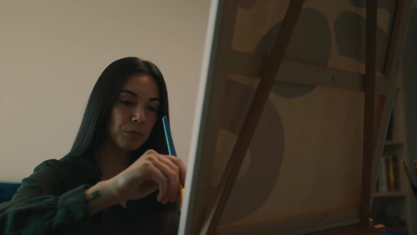 A woman painting on canvas with a brush