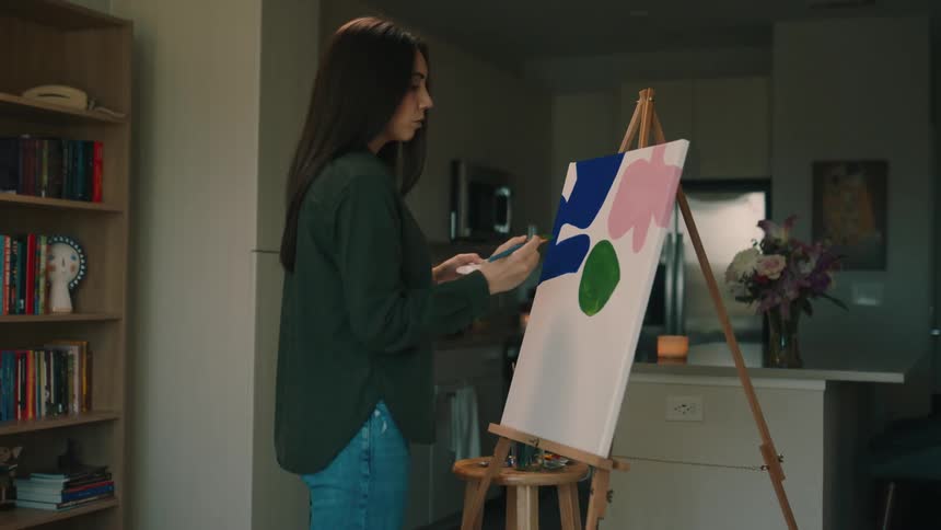 Woman painting a canvas indoors