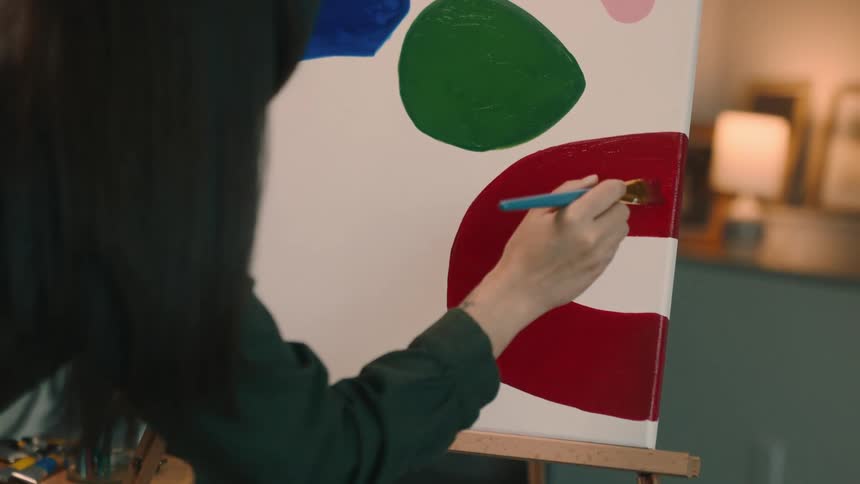 An artist painting on a canvas indoor