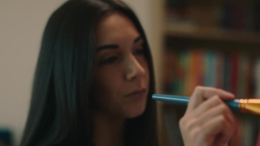 A clip of a woman wielding a paint brush and painting