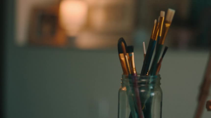 Art supplies sit on wooden stool in an art studio