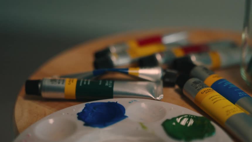 Series of paint for art and a plate for mixing paint on a table
