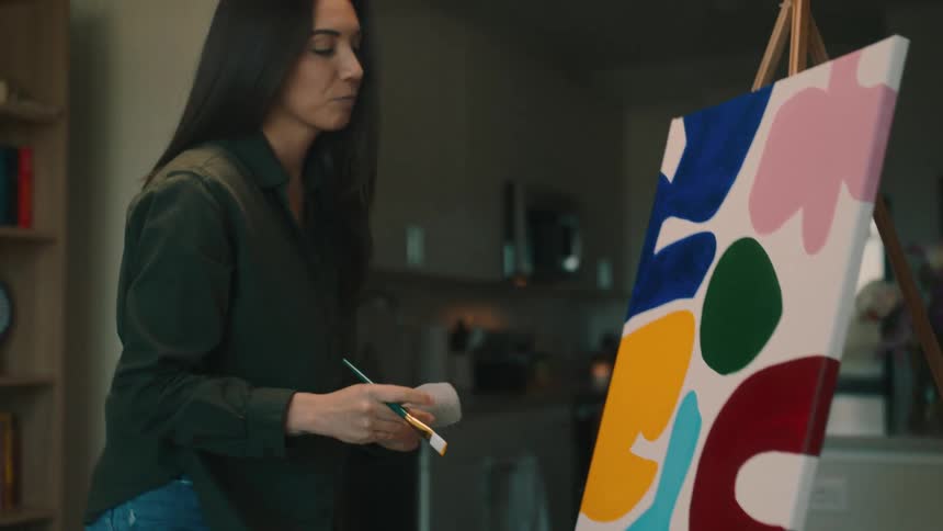 A woman painting a modern art canvas