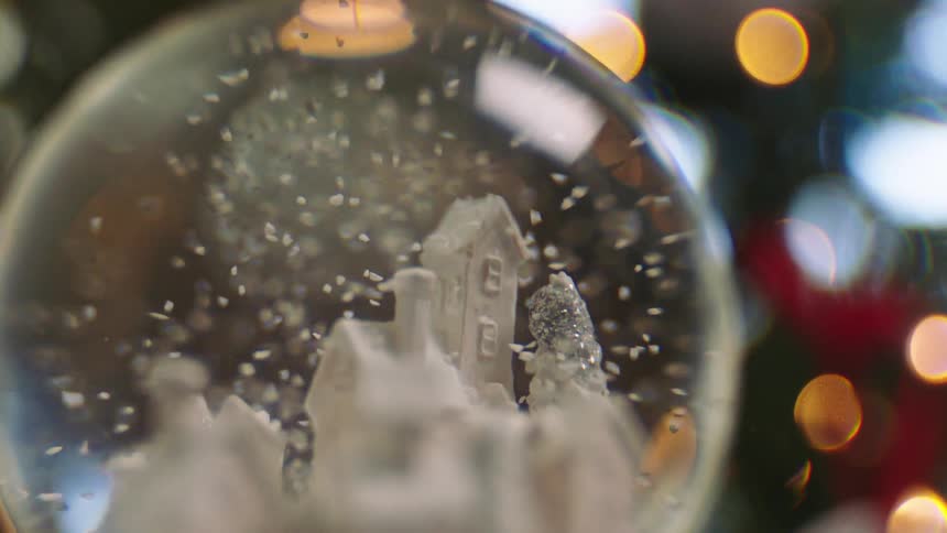 A snow globe with a carved house inside