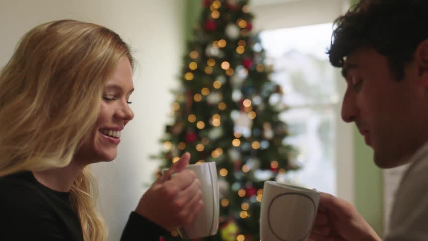A man and a woman enjoy a drink during christmas season