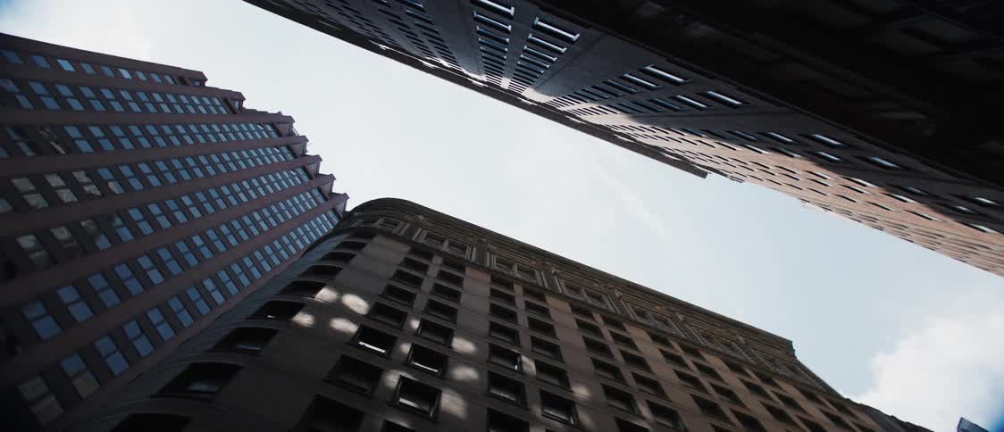Upward view of buildings on a day with sky with clouds
