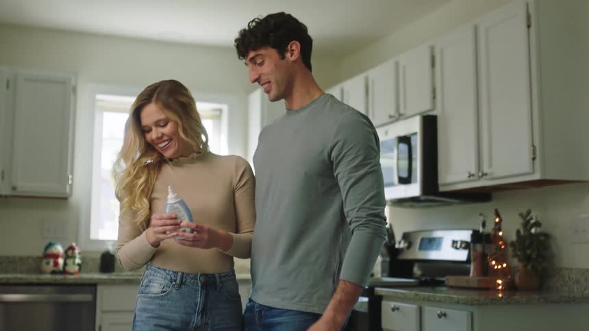 Couple in a romantic way preparing cookies and giving each other a kiss