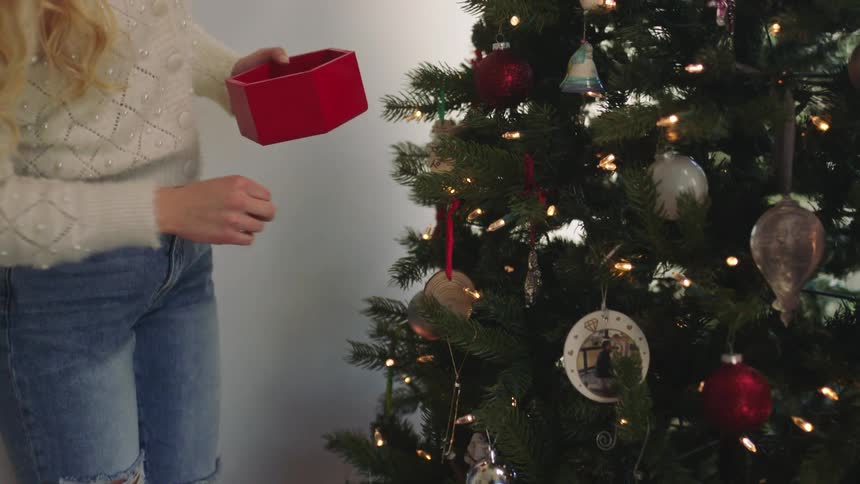 A woman decorating a christmas tree