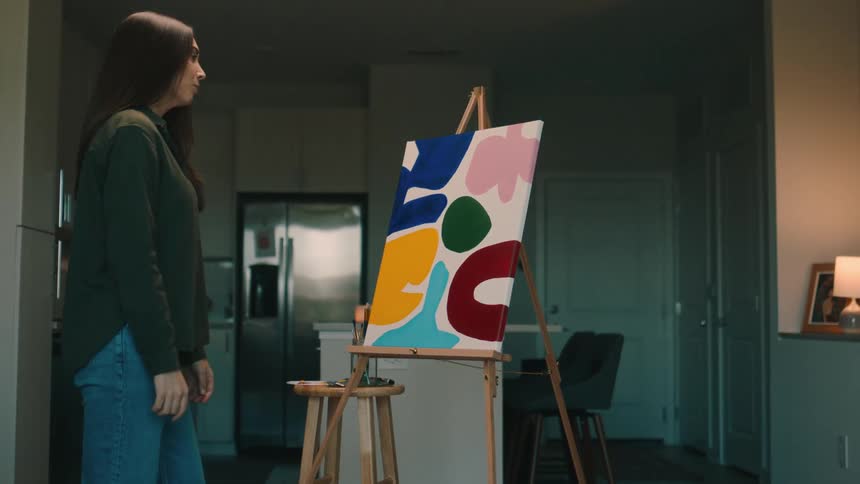 Painter finishing her painting taking a look leaving the room