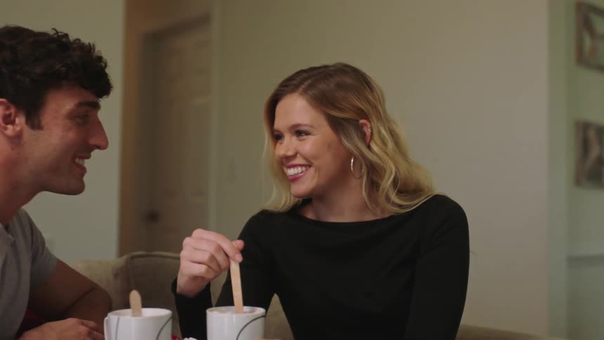Friends sit with beverages in room with fireplace and talk