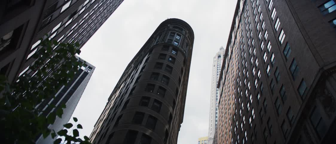 Upward view of buildings and skyscrapers in a cloudy sky in a metropolis