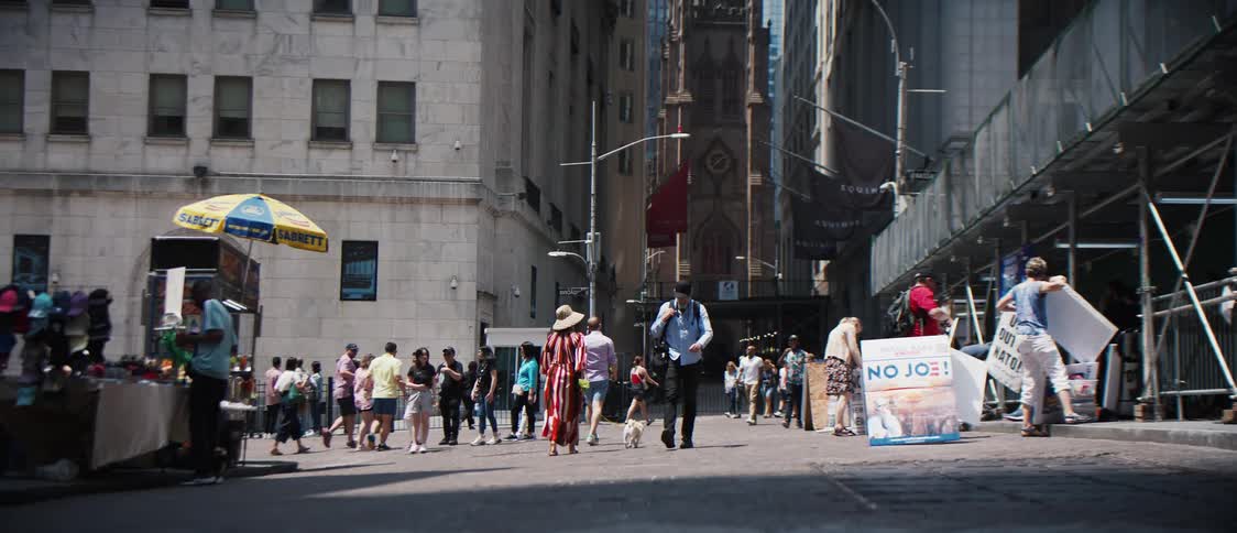 People walking on a pedestrian street with construction on one side and sales stands on the other