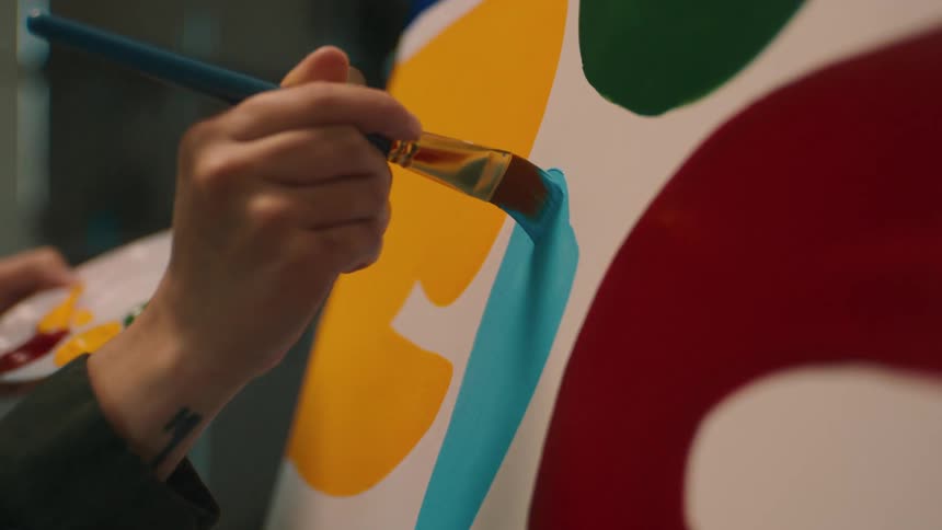 A person is painting on the canvas