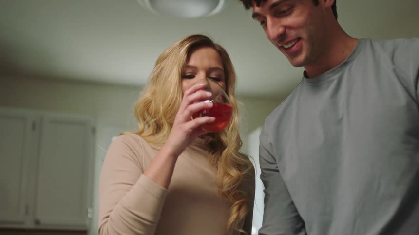 A man and a woman prepare food and drink alcohol
