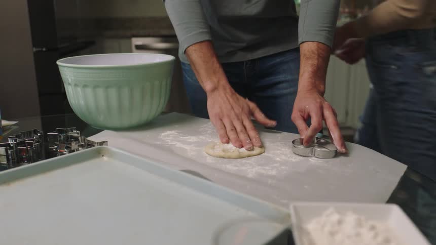 A young couple have fun making cookies in a kitchen
