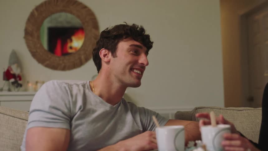 A couple having hot chocolate and marshmallows as they talk and laugh
