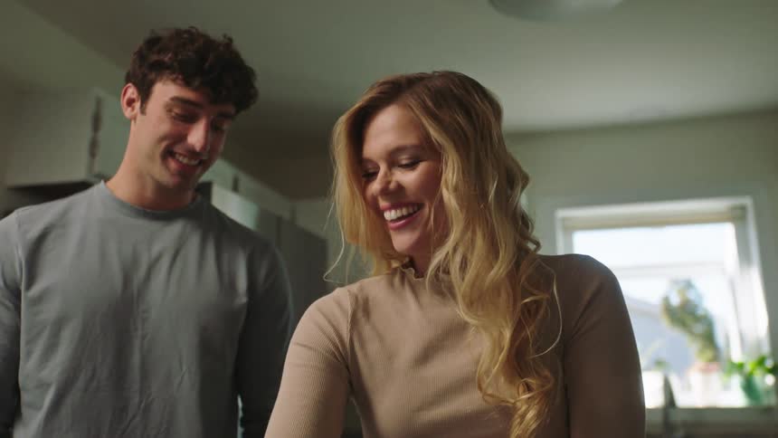 Couple cooking cookies and the man kissing his wife