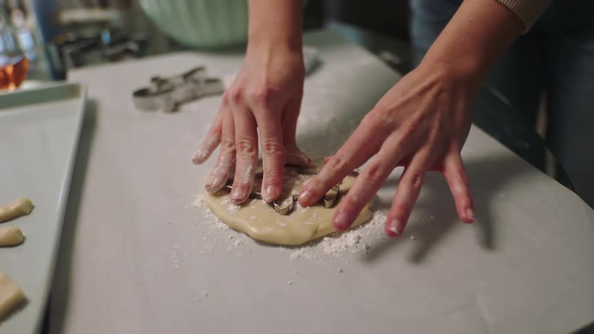 A person preparing cookies in doll molds