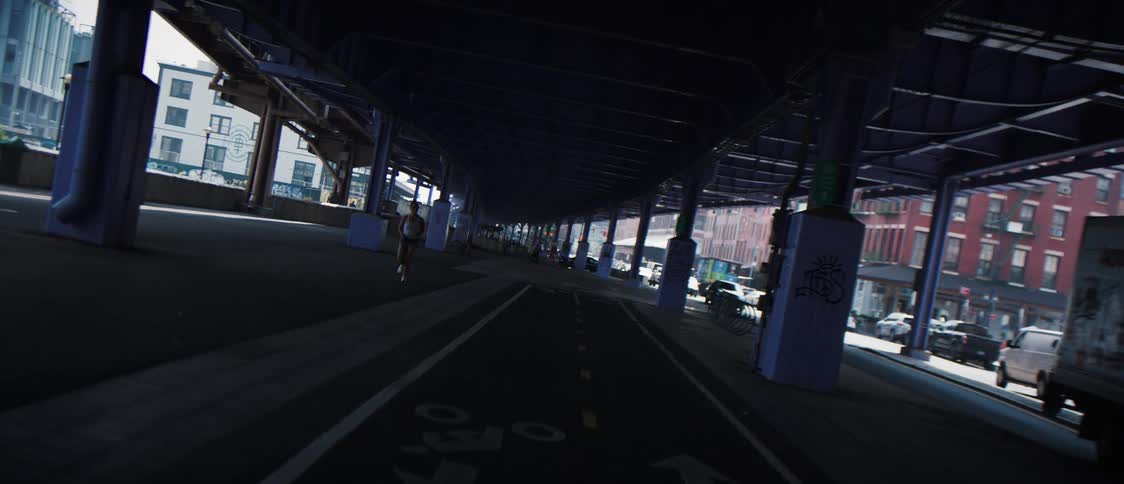 A jogger and traffic moves around a city street