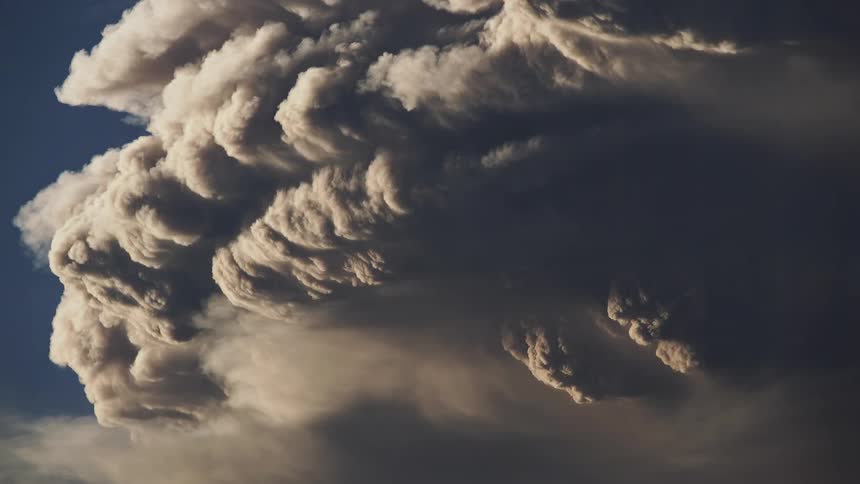 Dark clouds that look like part of a volcanic eruption roil in the sky