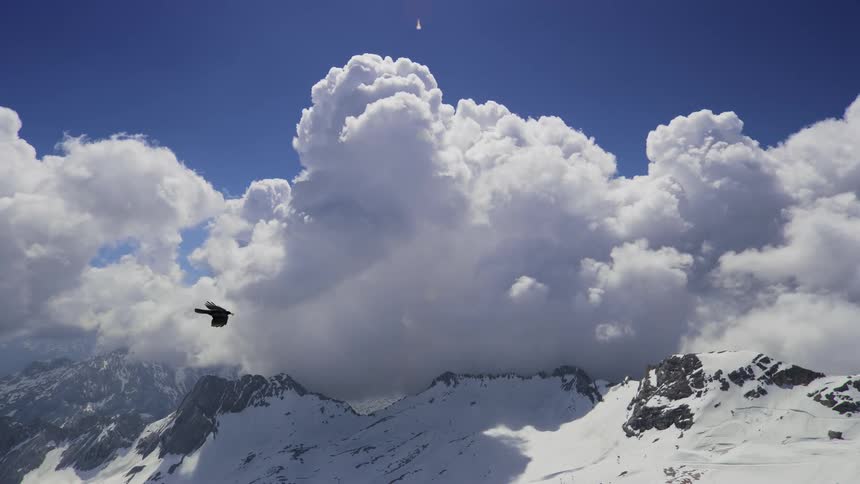 Mountain range covered by snow at cloud level in time lapse