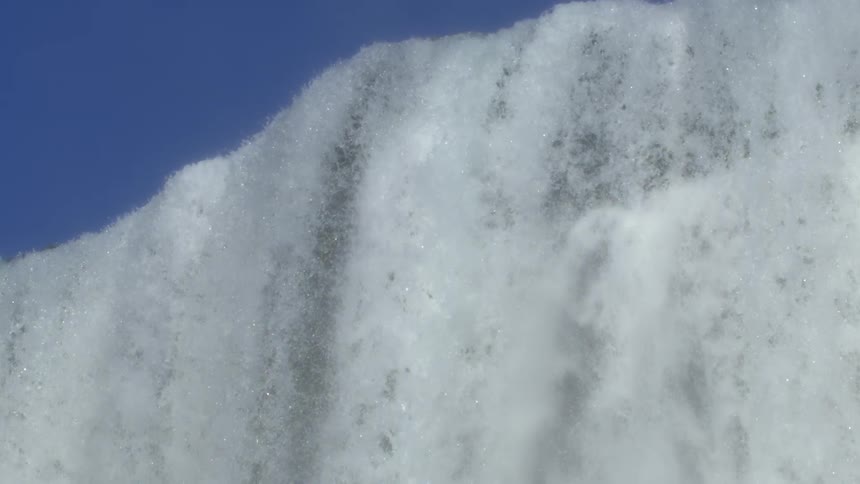 Waterfall with water in free fall against a blue sky