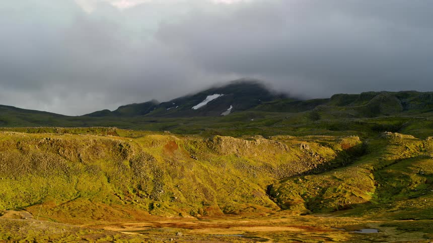 Panorama of a mountain range with moss and clouds passing in timelapse