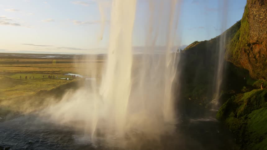 A thin layer of water falling from a waterfall and making a mist on the ground