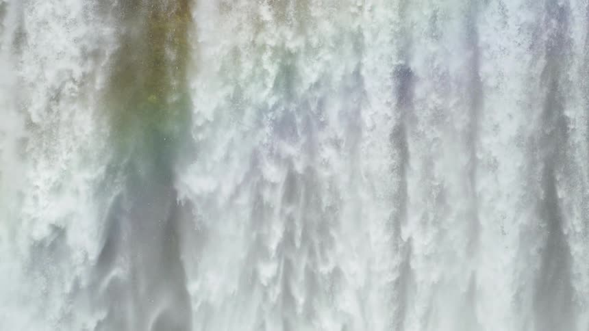 Panorama of a waterfall in free fall against a cloudless blue sky