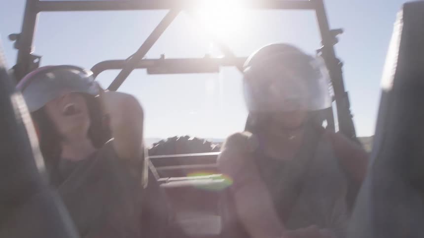 Two passengers sitting in the back seat of a moving buggy enjoying the vibe
