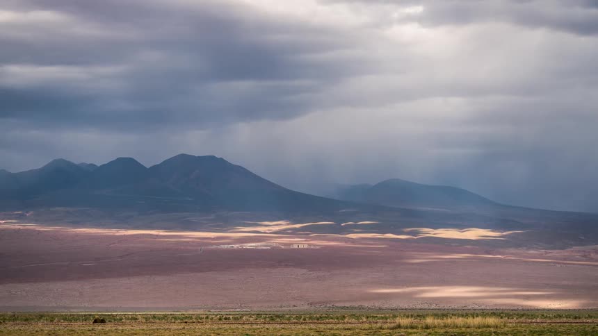Natural landscape of a misty mountain range next to deserted land during day time