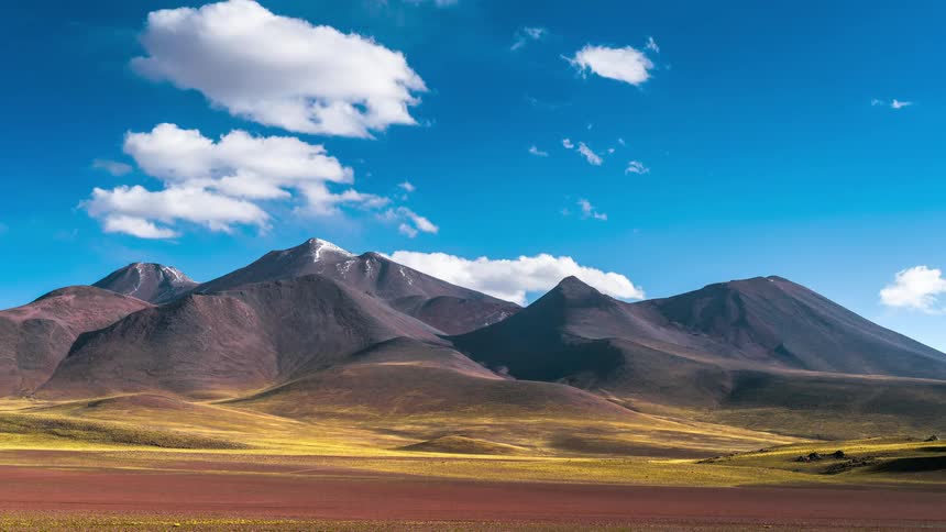 Time lapse cloud movement over purple mountain landscape