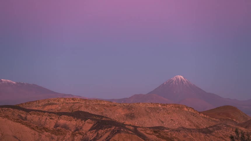 Landscape of mountains and plateau with a darkening day in timelapse