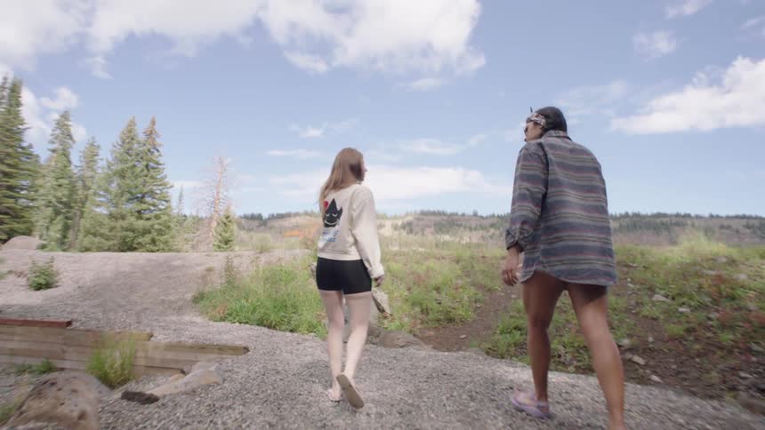 Two women walk along a path outdoors