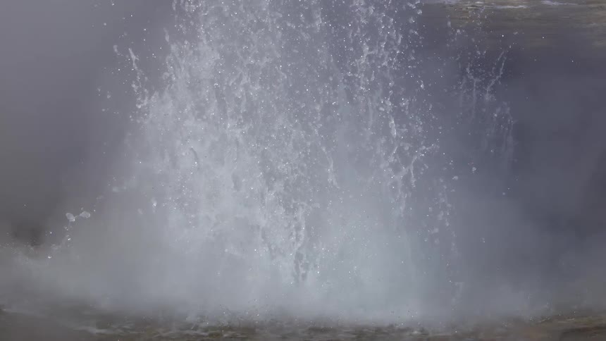 A geyser erupts throwing water and steam into the air