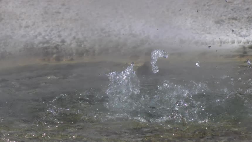 Crater with water bubbling and splashing upwards and a slow motion