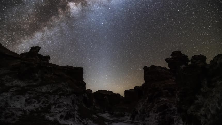 Starry sky illuminating the top of a cliff at night