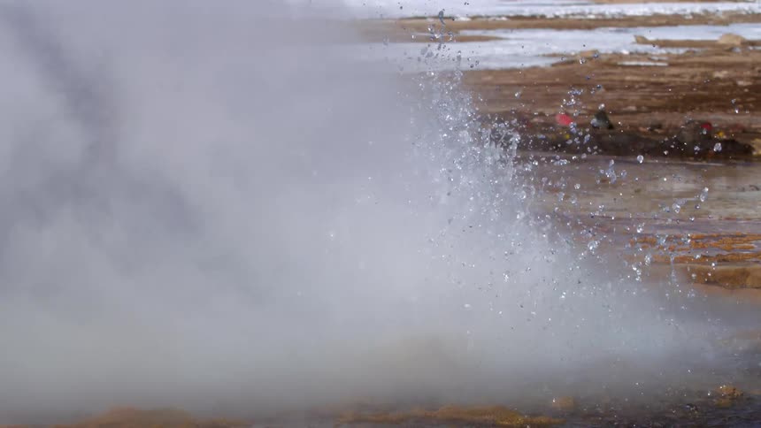 Rocky crater splashing water with hot smoke in slow motion