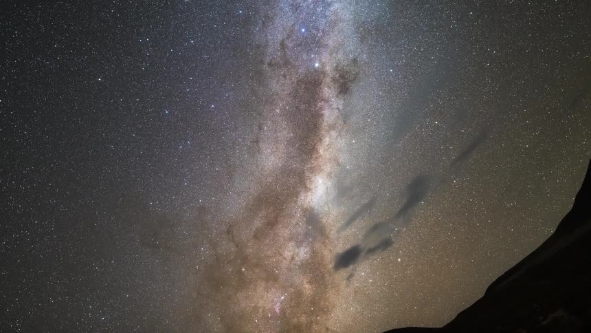 Panorama of the silhouette of mountains in a timelapse sky with a nebula