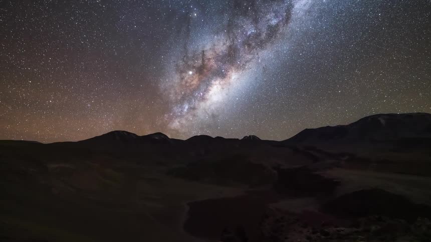 moon setting and revealing the bright milkyway over a desert mountain range
