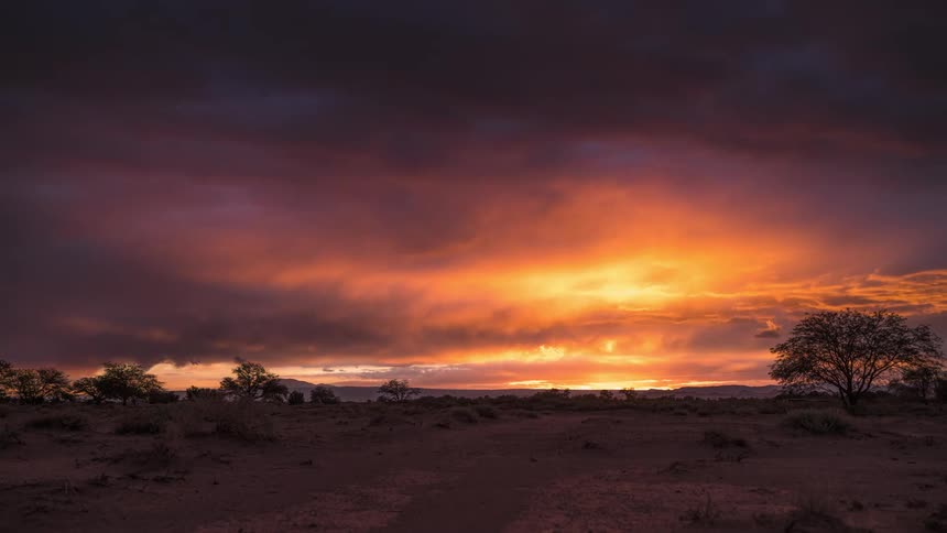 A car stops on a road as the sunset occurs