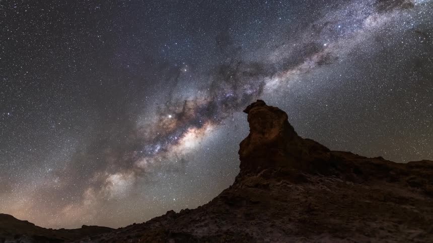 Natural landscape of rocky mountains with night sky with nebulae in timelapse