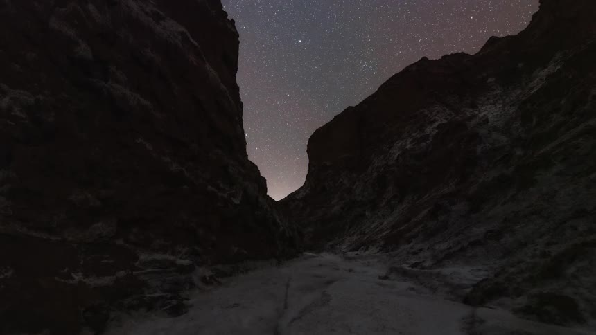 Landscape of rocky walls with the sun setting and the day falling in timelapse