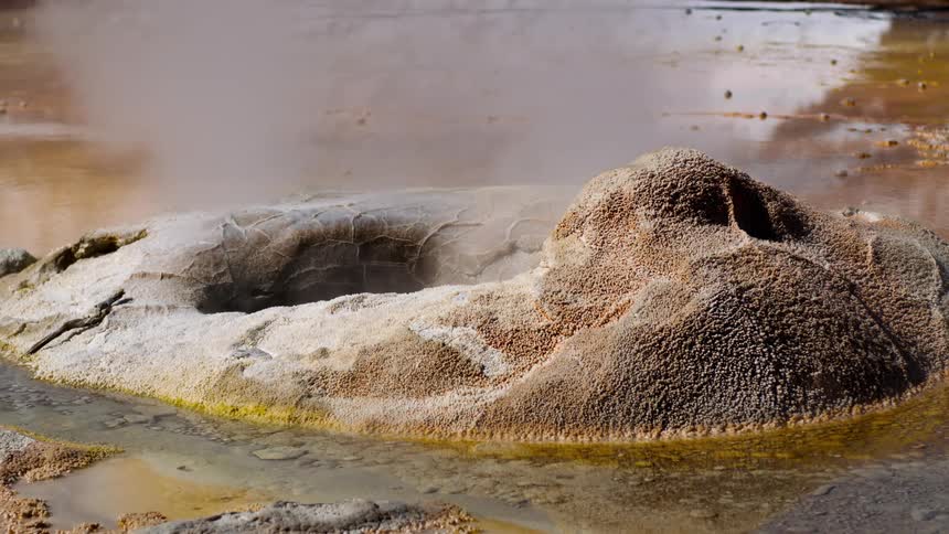 Small rocky crater with a smoke hole in the middle of a lake