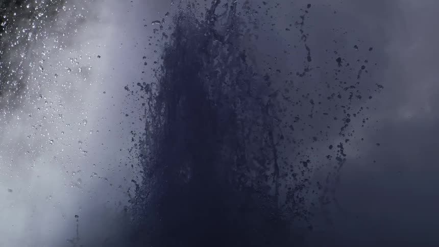 Liquid from geyser erupts into air creating vapor that obscures night sky