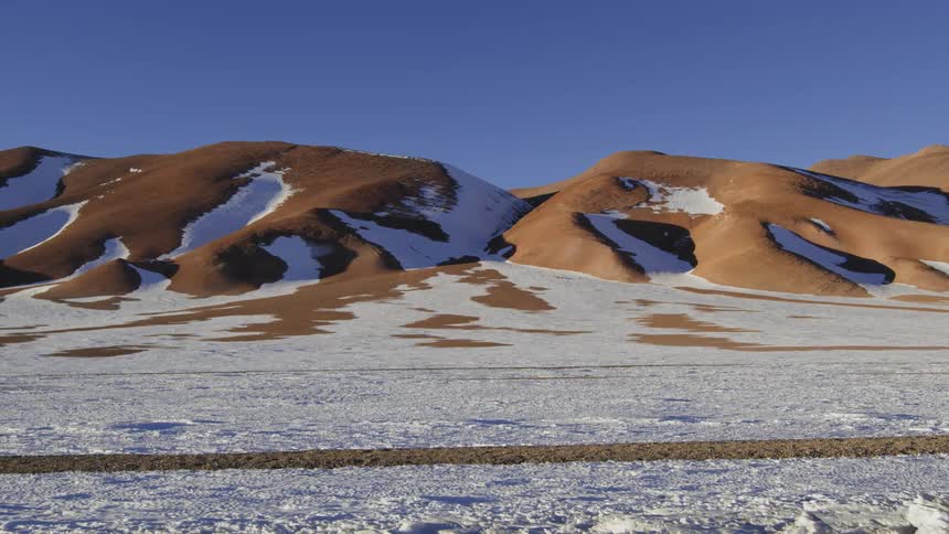 Patches of snow cover flat land and hills