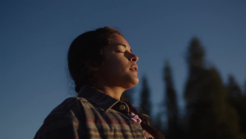 Portrait of a young woman taking a deep breath and opening her eyes